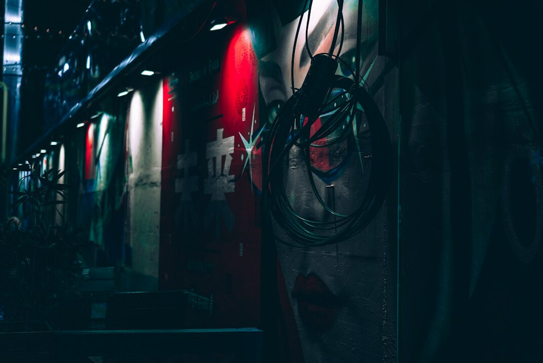Rack of broadcast equipment with patched cables and glowing status lights
