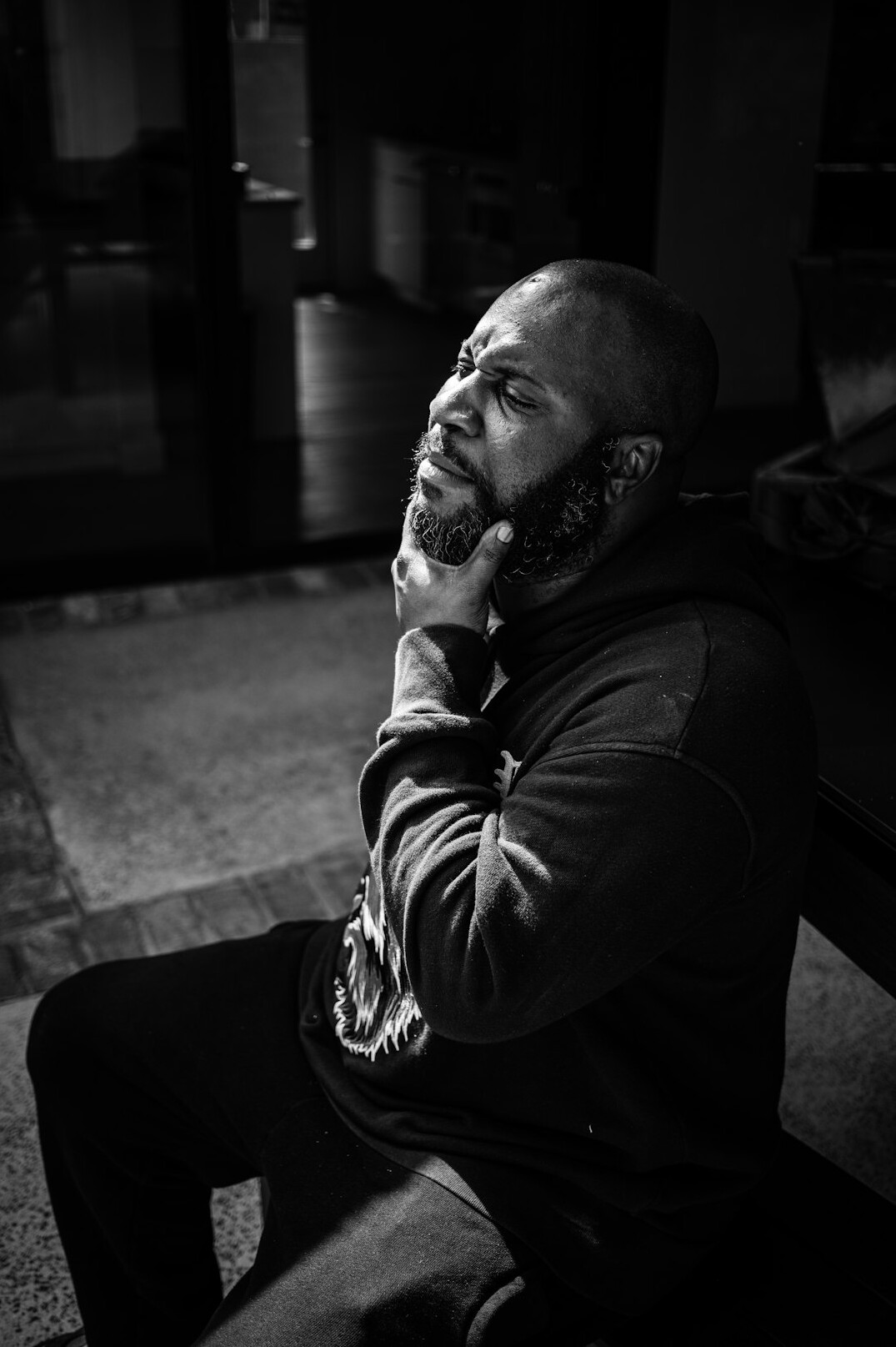 Portrait of a man with a short grey beard wearing a dark shirt and headset around his neck