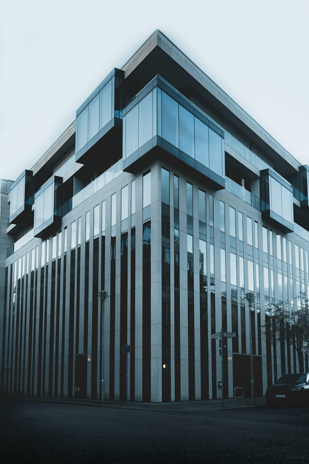 Modern glass fronted media building with a reception area lit at dusk