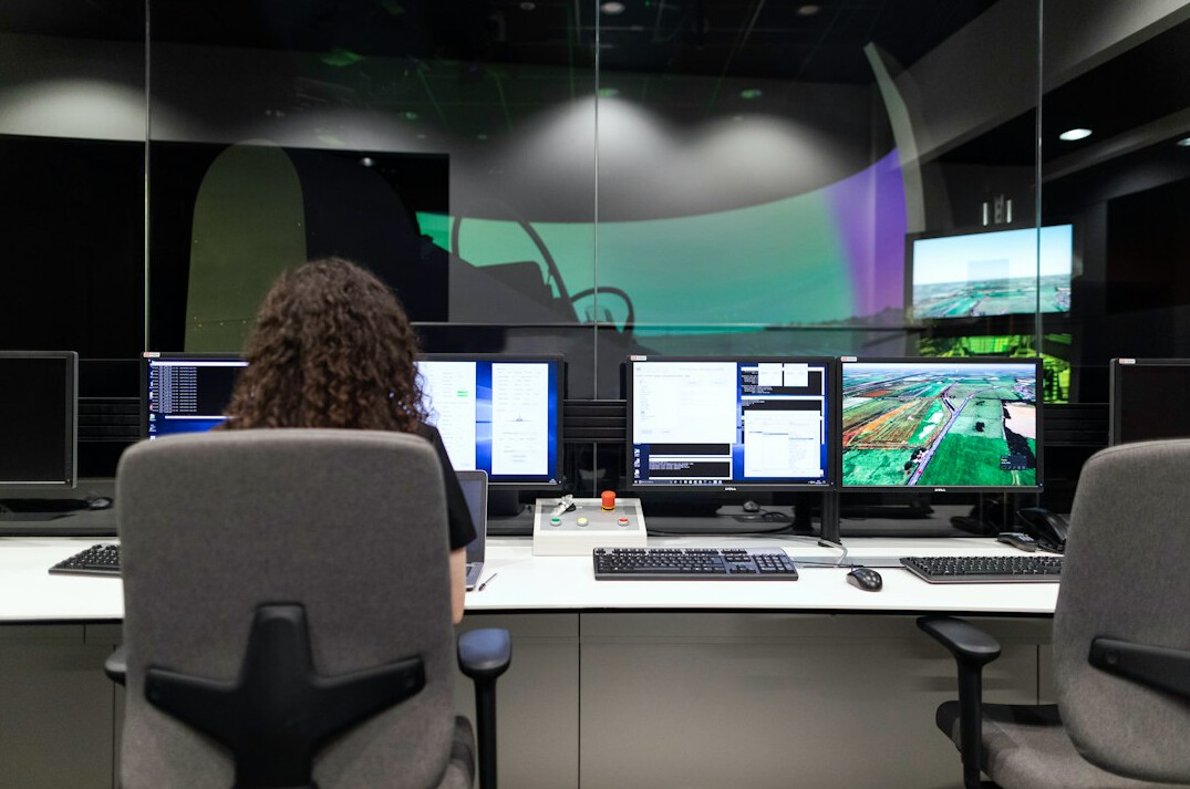 Production control room with a wall of monitors and a vision mixer desk