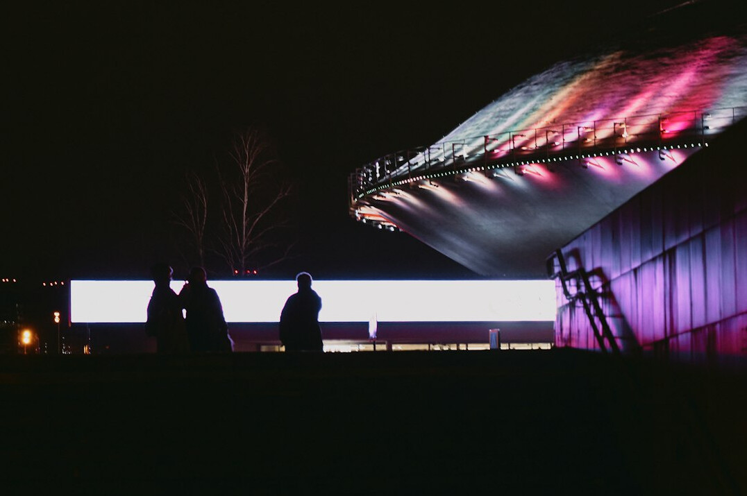 Live show stage with a large LED screen, colourful lights and a camera crane